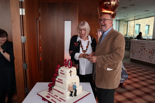 Colin and Rhona Stanbury cutting their 40th anniversary cake
